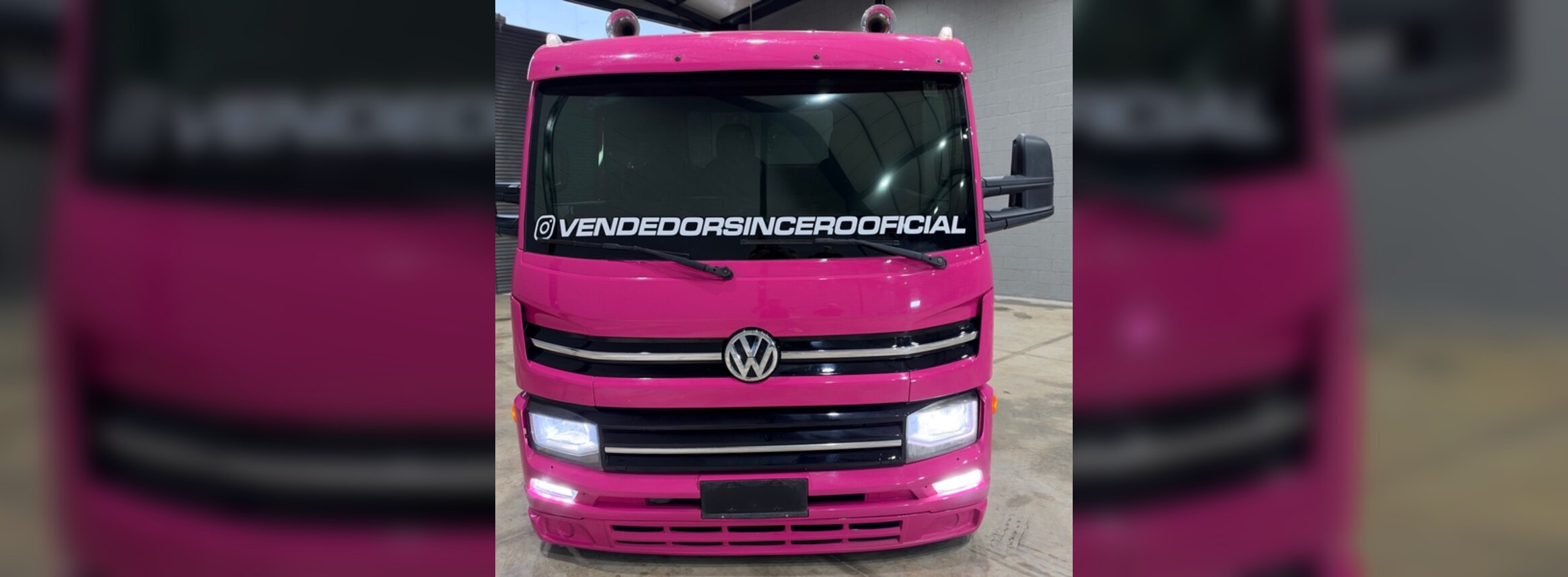 Frente do Volkswagen Delivery 11.180 rosa com grade e emblema VW